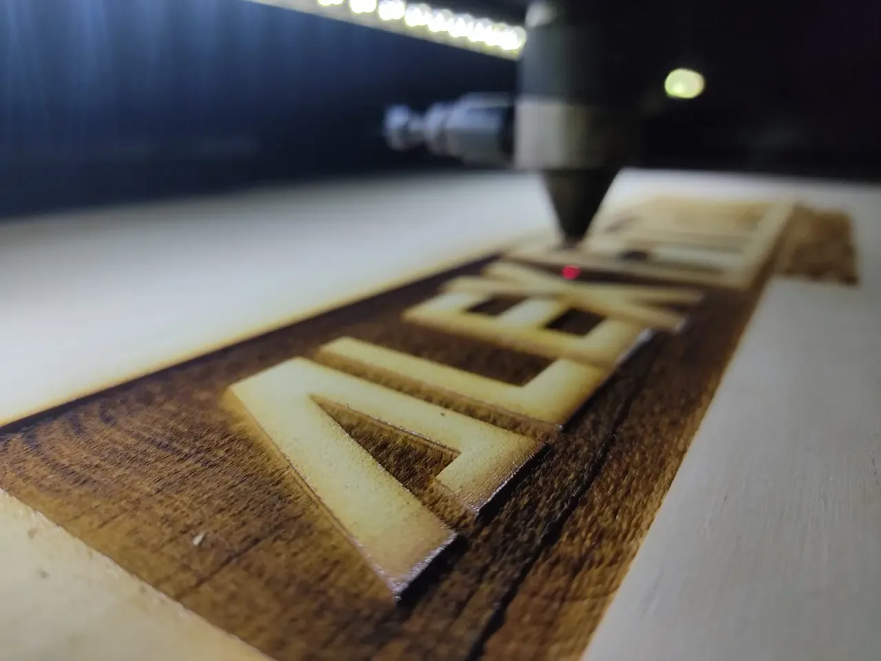 Máquina láser grabando un nombre sobre madera